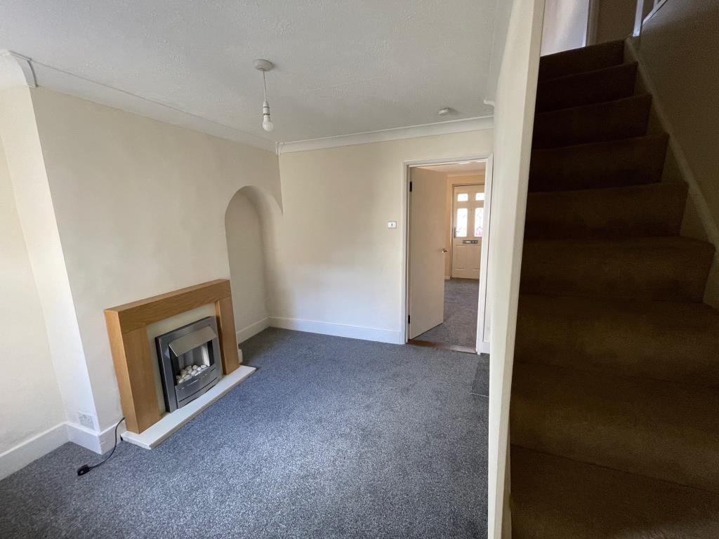 Lot: 107 - TWO-BEDROOM TERRACE HOUSE - Dining room with fireplace and stairs to first floor